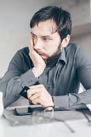 Tired man thinking about his credit card and finances late at night