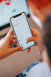 Person making first small investment on phone app feeling hopeful about the future