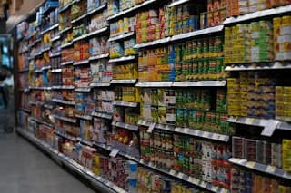 Grocery store aisle with shopping cart showing budget grocery shopping