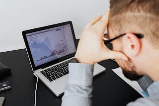 Person confused and overwhelmed by financial charts and investment options