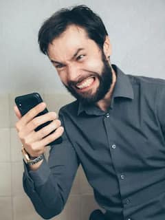 person frustrated and angry looking at budgeting app on phone