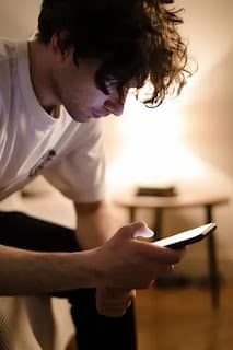 person staring at phone screen worried about money and investing